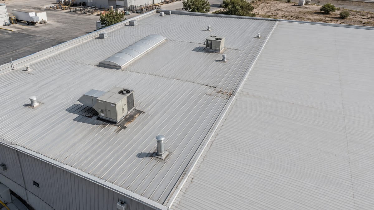 Cubierta metálica de una nave industrial con domos y equipos